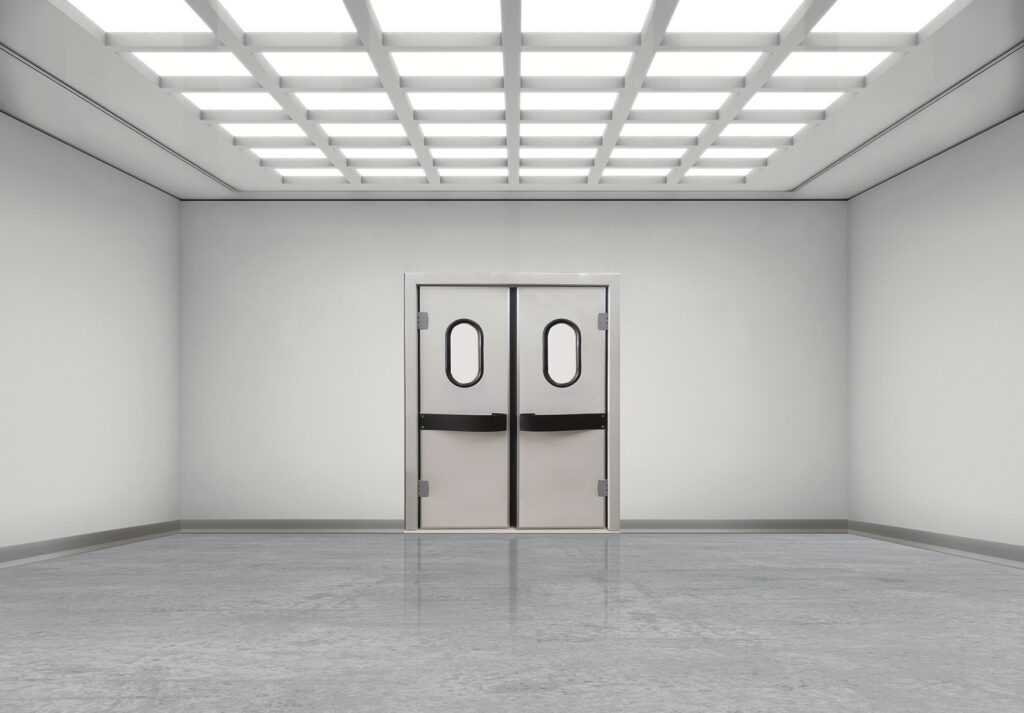 Empty, brightly lit room with double swing doors and grid ceiling lights.
