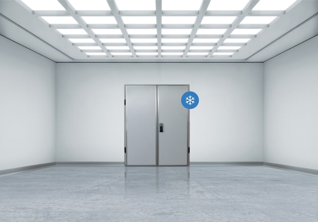 Bright sterile room with grid lights and a steel double door with snowflake